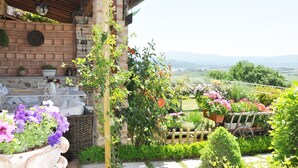 Ein Garten mit Blumentöpfen, einem Holzzaun und Blick ins Grüne.