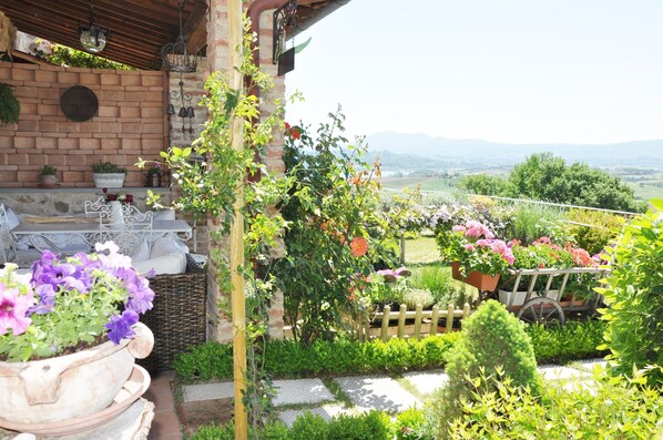 Un jardin agrémenté de plantes en pot, une clôture en bois et une vue sur la campagne.