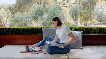 Relax in a serene garden setting with a comfortable bench and a table for casual dining.