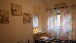 A bedroom with a bed, a desk, and a chair. There are three paintings on the wall. - Holiday Apartment Maison Velia in San Giovanni Colli Albani Appio Latino district (Roma)