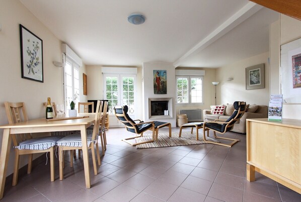 TV connectée, cheminée, livres, chaîne hi-fi