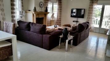 Flatscreentelevisie, een open haard en boeken