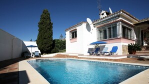 A swimming pool with lounge chairs and a white building with a satellite dish. -  Semi-secluded 3 Bed, 2 bath Tranquil Family Villa with Pool & Gardens  (Estepona)