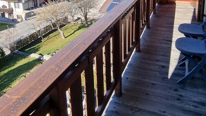 Een houten balkon met uitzicht op een stad en bergen.