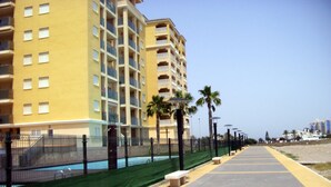 A multi-story hotel with balconies, a pool, and a beachside walkway. - Beautiful, double BEACH FRONT Penthouse, Breathtaking View, Wi-Fi, SAT TV, Pool (San Javier)