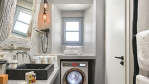 A compact bathroom with a large mirror, a washing machine, and a towel rack. - Brand New!!! Lindos shore Superior Studio just above Lindos main beach !!! (Rhodes)