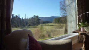 A room with a window overlooking a landscape. - Fabulous location, luxury lodge for 8+2 in cots, hot tub, garden, garage, dogs   (Aviemore)