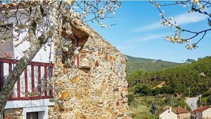 A stone building with a red balcony, surrounded by greenery and hills. - Casas da Encosta, Shale Houses, Accommodation in Shale Village - Free Wifi (Sobreira Formosa)