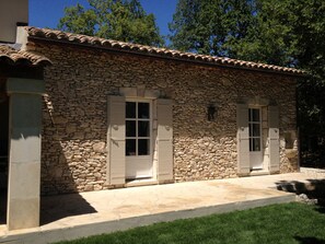 A stone building with a tiled roof, two windows with shutters, and a stone pathway leading to the entrance. - Beautiful Provence House in the Luberon - Heated Swimming Pool & Large Gardens. (Roussillon)