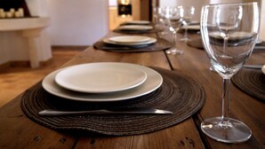 A dining table set with plates, cutlery, and wine glasses, with a fireplace in the background. - Beautiful Provence House in the Luberon - Heated Swimming Pool & Large Gardens. (Roussillon)