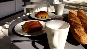 A table with a croissant, a cup, and a baguette. - Beautiful Provence House in the Luberon - Heated Swimming Pool & Large Gardens. (Roussillon)