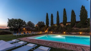 A swimming pool with lounge chairs and a covered seating area, surrounded by tall cypress trees and a stone wall. - Il Poderuccio 17, Emma Villas (Cetona (Siena))