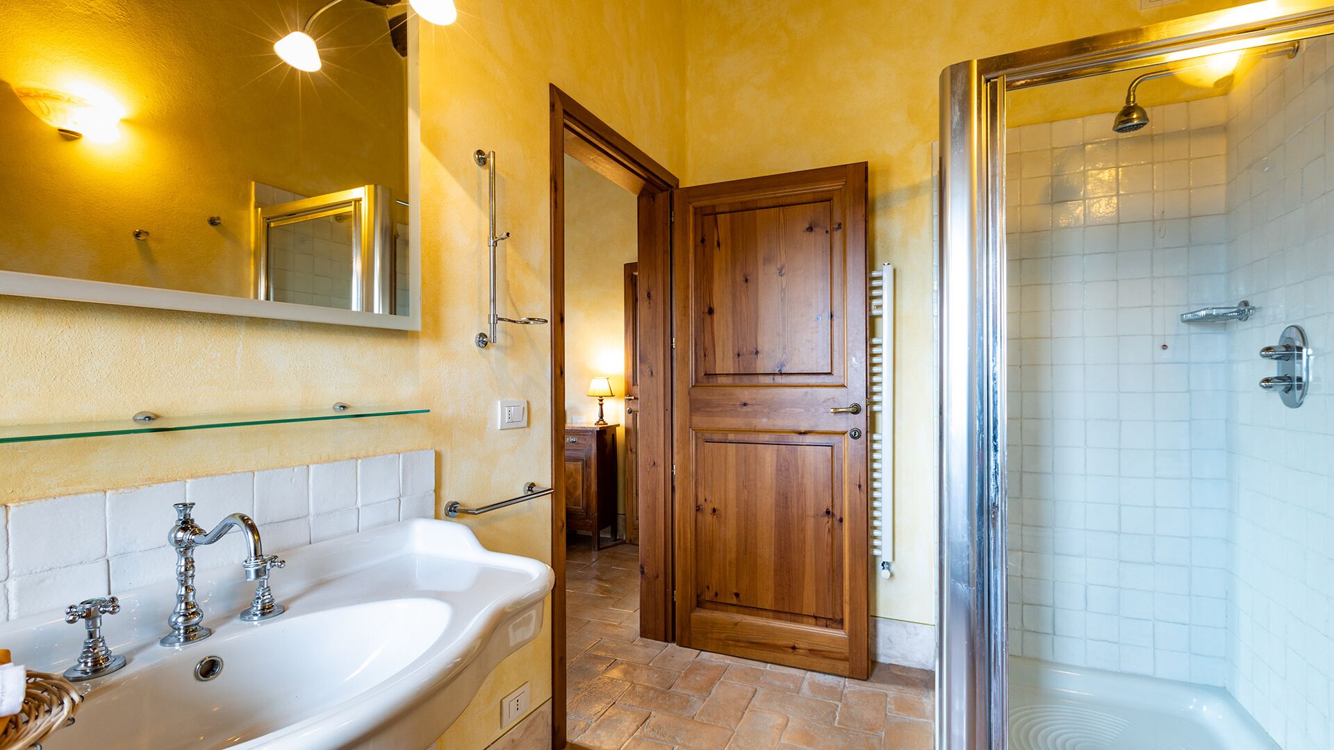 Une salle de bain avec une baignoire blanche, une porte en bois et une cabine de douche en verre.