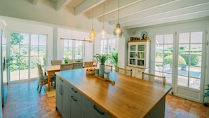 A spacious kitchen with a large island, wooden cabinets, and pendant lighting. - Charming farmhouse with private heated pool and amazing mountain views. (Mont-De-Marrast)