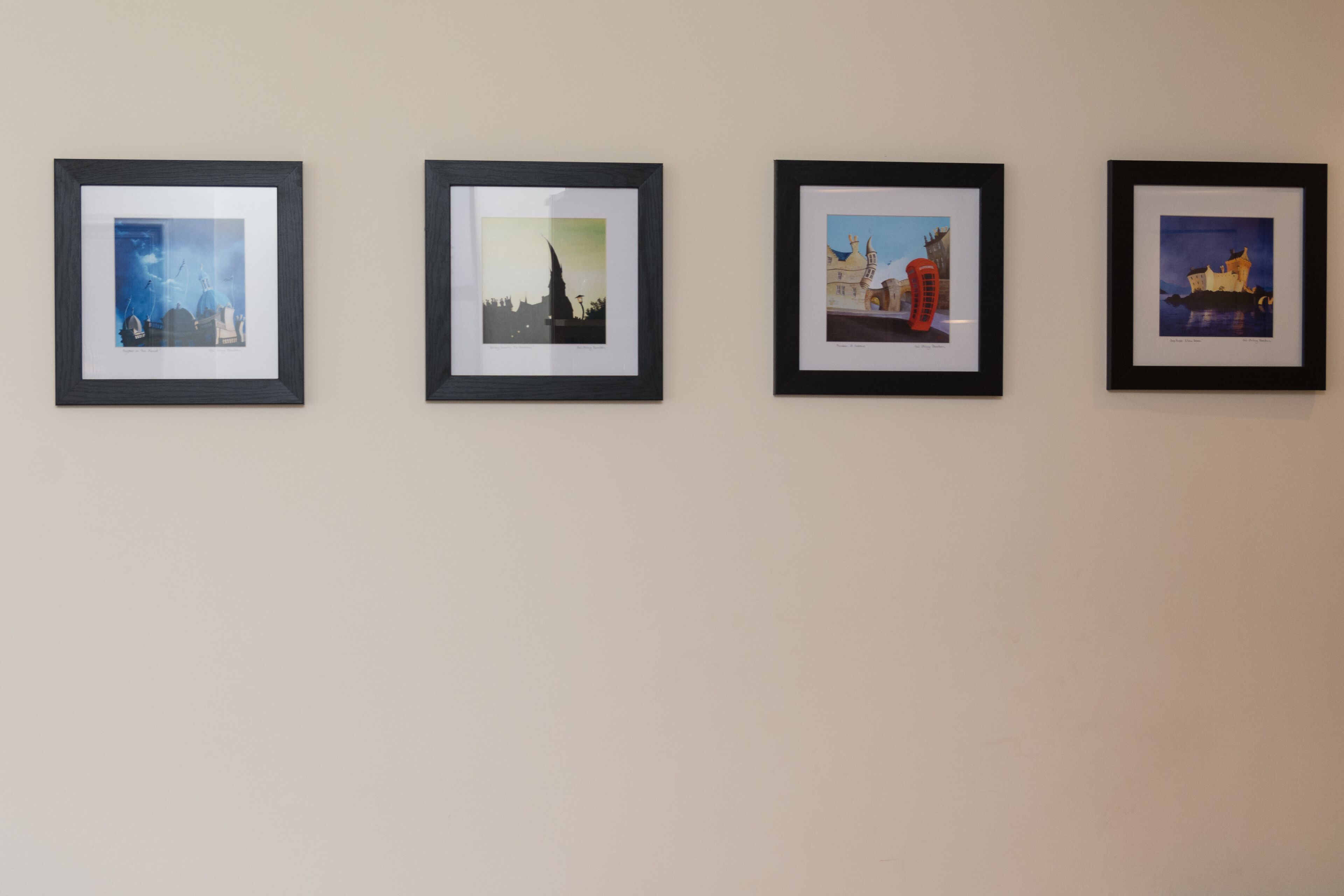 Four framed pictures on a wall.