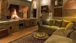 Una sala de estar acogedora con chimenea, un sofá y una alfombra estampada.