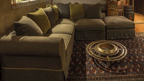 Un rincón acogedor para leer con un sofá modular, una estantería y una alfombra estampada.