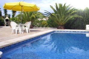 Una piscina al aire libre, tumbonas