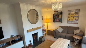 Un salon avec une cheminée, un canapé, une table basse et une bibliothèque.