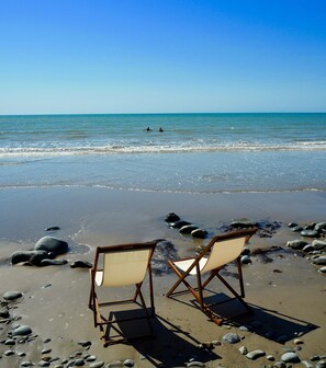 Two empty folding chairs on a rocky beach with the ocean in the background. - Lovely cottage in Snowdonia, private hot tub, by mountains & award winning beach (Friog)