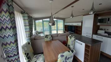 A compact kitchen with a dining area, a microwave, and a television.