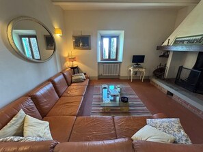 Fireplace, books - Poggio Corsucci.Historic stone house with swimming pool and enchanting view.     (Loro Ciuffenna (Province of Arezzo))