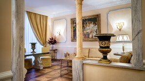 A room with a marble floor, a sofa, a table, and a painting on the wall.