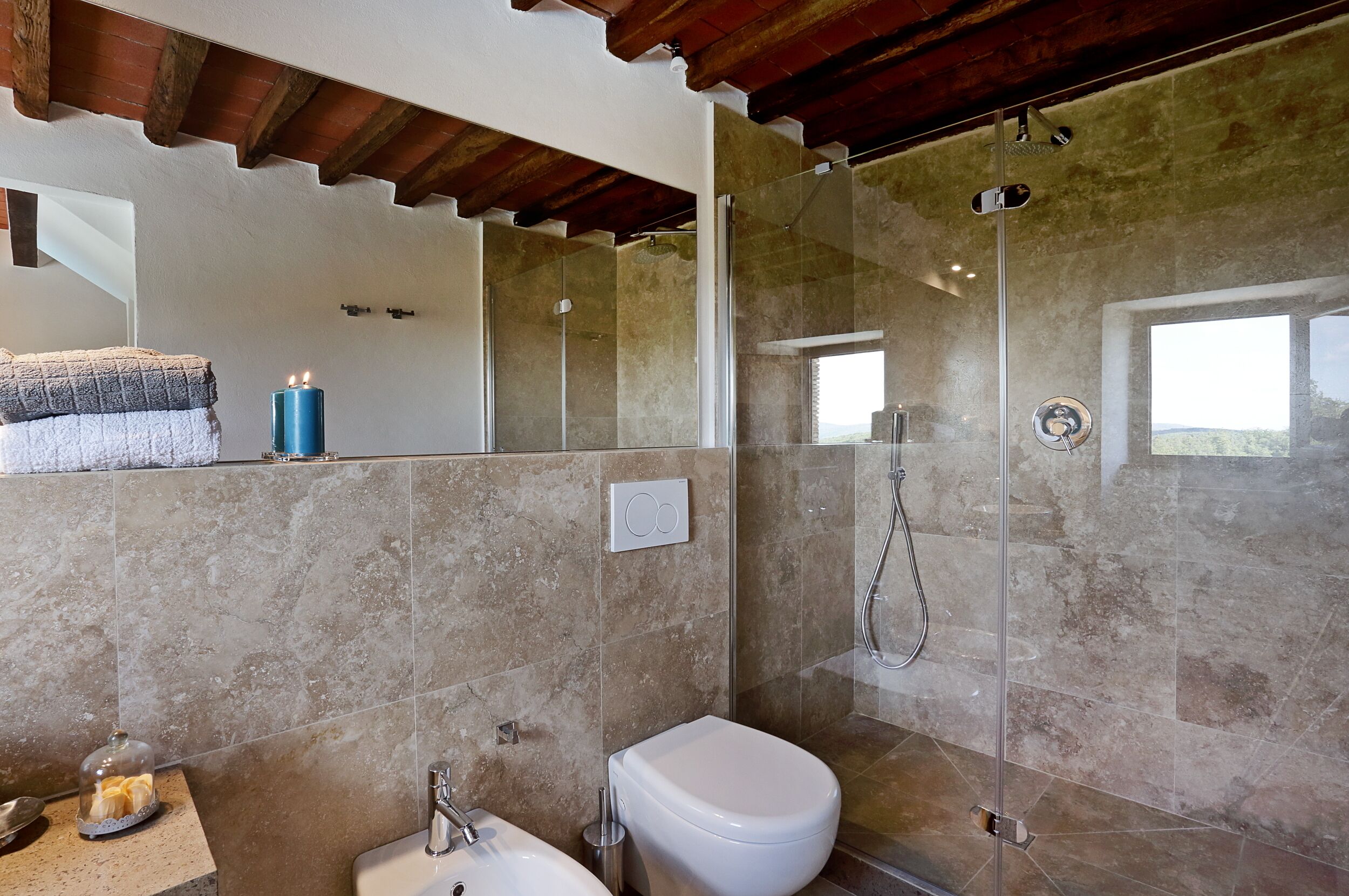 A bathroom with a glass-enclosed shower, a white toilet, and a sink.