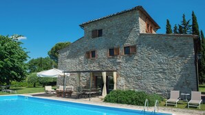 A stone villa with a swimming pool, outdoor seating, and a pergola. - Secluded villa between Chianti vineyards, private pool, tennis, large garden (Gaiole In Chianti)