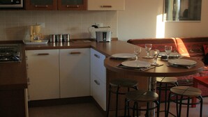 A kitchen with a dining area, including a microwave, toaster, and stools. - Stunning views - Beautiful holiday home in a friendly Italian village  (Dumenza (VA))