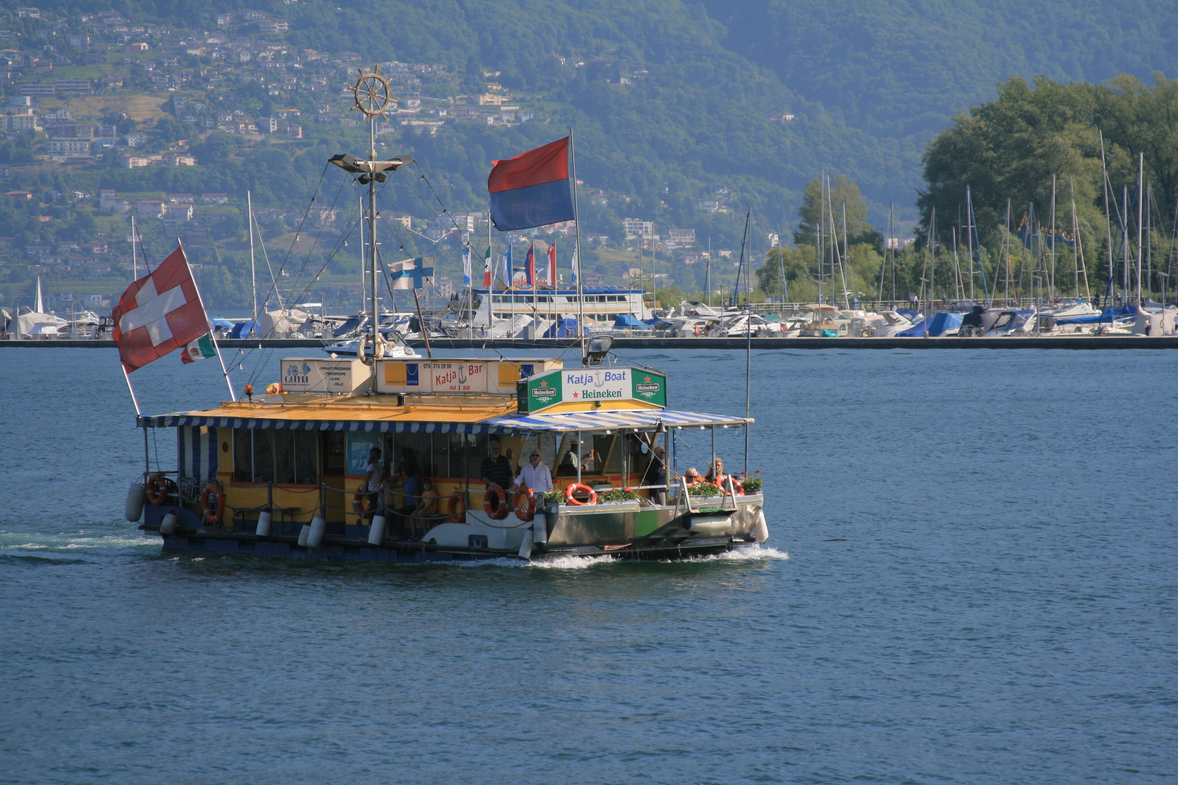 Ein Boot mit Schweizer Flagge, einem Heineken-Schild und einem Rettungsring.