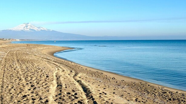 Une plage avec une montagne en arrière-plan.
