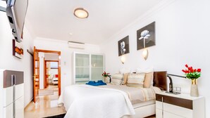 Een moderne slaapkamer met een bed, nachtkastje en een bedtafel met een lamp.