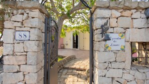 A stone gate with a sign reading "Giardino dei Limoni" and a house number sign "88".