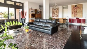 A modern living room with a black leather sofa, a glass coffee table, and a bookshelf. - Terrace on the lake,private garage (Lugano)