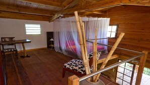 L'intérieur d'un chalet en bois, avec un lit, une table et une chaise.