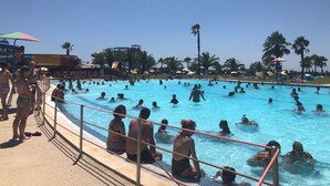 Ein Schwimmbecken mit Personen im Wasser und am Beckenrand.