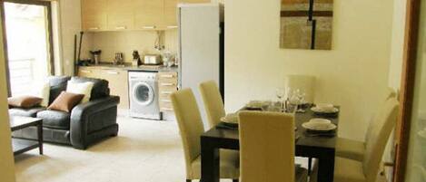 A modern living room with a sofa and a dining table set for four.