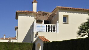 A building with a sign for 'Family Beach' and a balcony with a white railing.