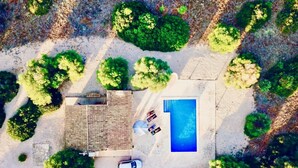 Vue aérienne d’une propriété dotée d’une piscine, d’un patio couvert et d’un espace verdoyant.