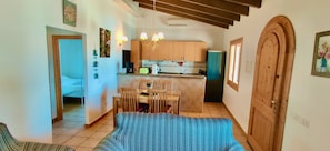 Un espacio habitable compacto con zona de comedor, cocina y una puerta de madera grande.