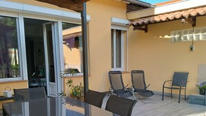 An outdoor patio with a glass table and chairs, a wooden ceiling, and a tiled floor. - Apartment in a small house in the heart of Cagnes-sur-Mer (Cagnes-Sur-Mer)