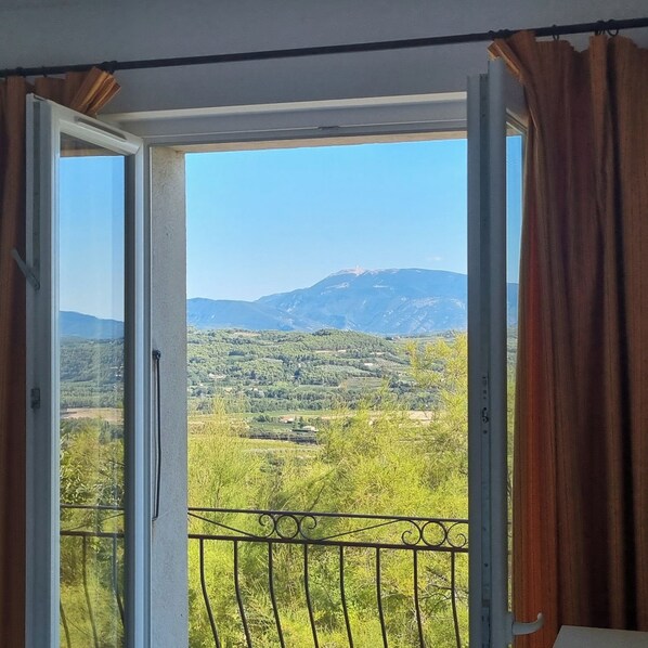 Una habitación con un amplio ventanal que ofrece vistas a un paisaje montañoso.