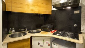 Cozinha compacta com pia, fogão e torradeira.