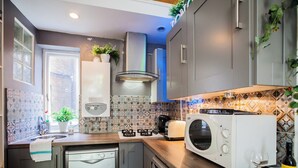 A modern kitchen with grey cabinets, a dishwasher, a microwave, and a toaster.