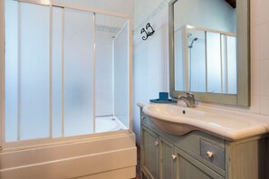 Een bad/douchecombinatie, een haardroger, een bidet, handdoeken