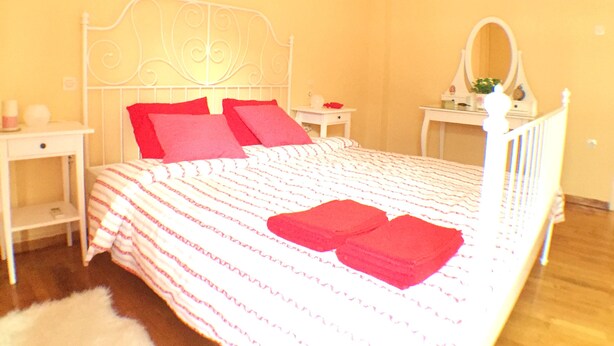 Ein Schlafzimmer mit Bett, Nachttisch, Spiegel und Klimaanlage.