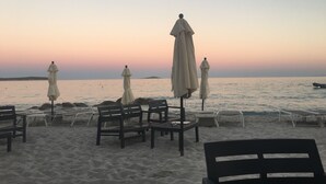 A beach with several umbrellas and chairs, a calm sea, and a clear sky. - Cosy, quiet villa 150 metres from the sea and swimming pool Tennis included (Porto-Vecchio)