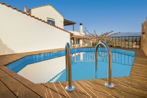 Una piscina al aire libre, una piscina climatizada, sombrillas