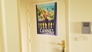 Una porta con un manifesto del Festival di Cannes, un campanello e un pannello di sicurezza.